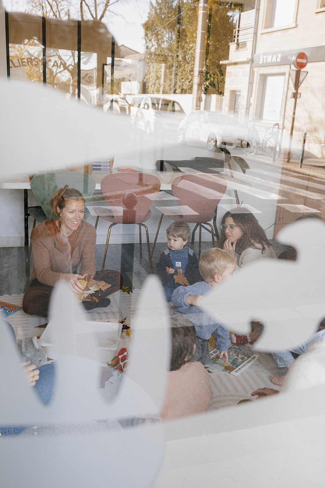 Les jeunes enfants d'une école maternelle apprennent à dessiner des feuilles dans une pièce spacieuse.